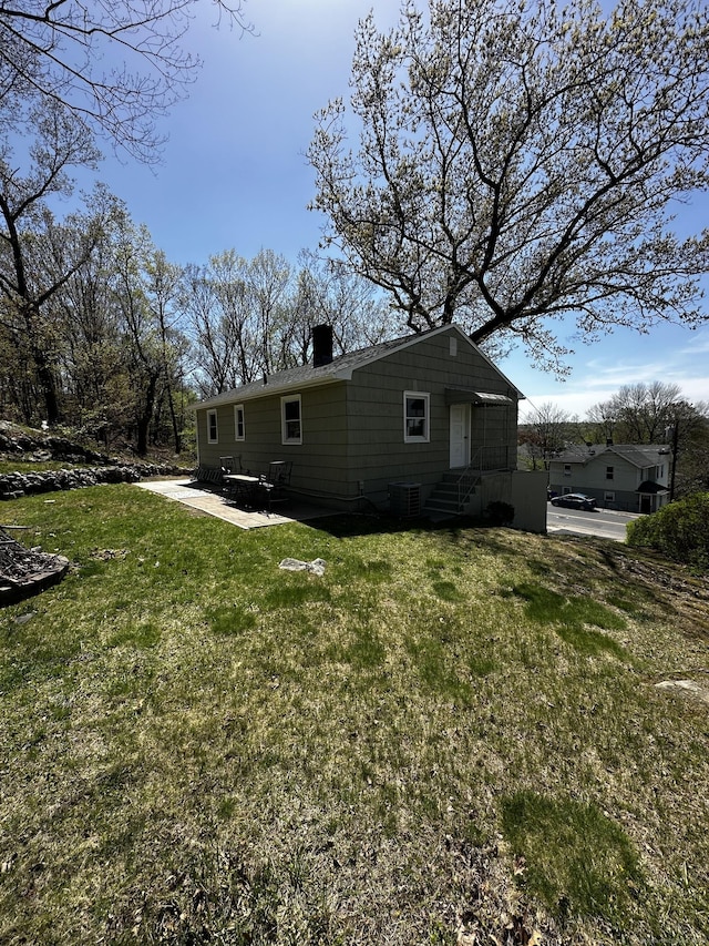163 Sylvan Ave, Waterbury, CT 06706 - view of side of home with a yard, a patio area, and a chimney