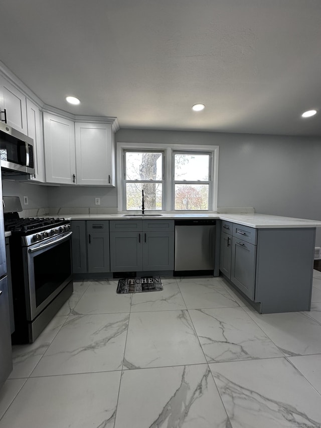 163 Sylvan Ave, Waterbury, CT 06706 - kitchen with stainless steel appliances, gray cabinets, recessed lighting, a peninsula, and light countertops
