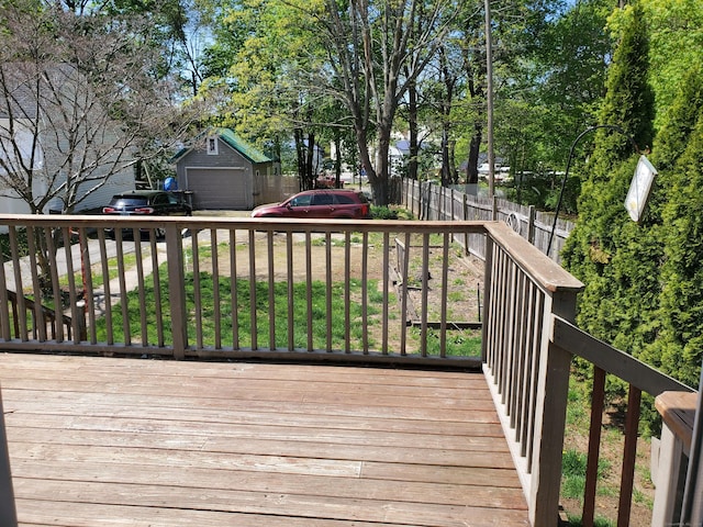 wooden deck featuring fence and a garage