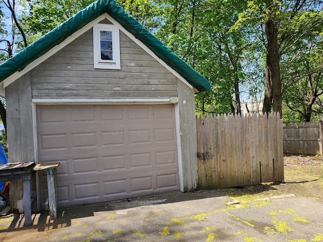 detached garage featuring fence
