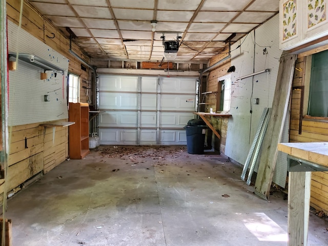 garage with wood walls and a garage door opener
