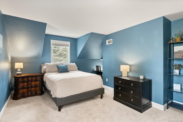 bedroom with light colored carpet and baseboards