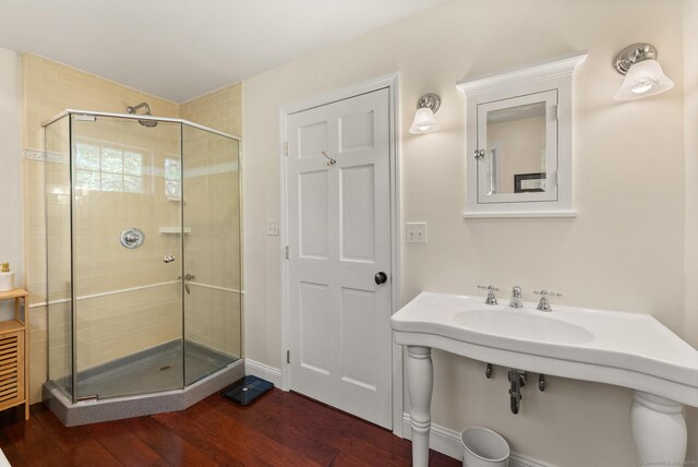full bathroom with wood finished floors and a shower stall