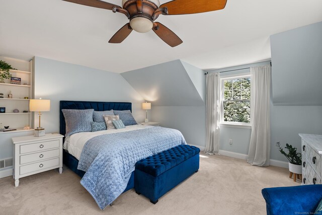 bedroom featuring a ceiling fan, light carpet, visible vents, baseboards, and vaulted ceiling