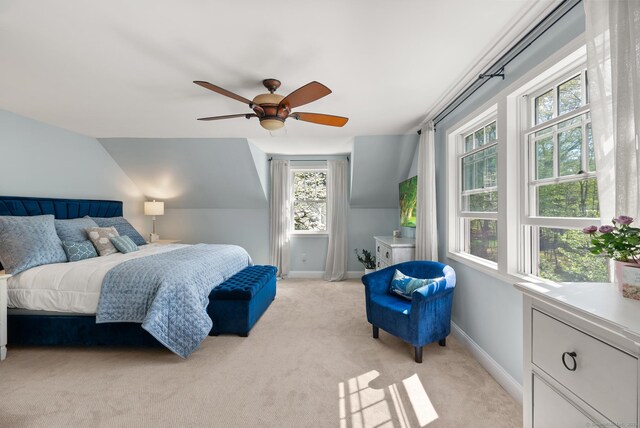 bedroom featuring light carpet, baseboards, ceiling fan, and lofted ceiling