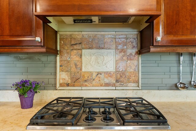 kitchen with tasteful backsplash, stainless steel gas cooktop, and under cabinet range hood