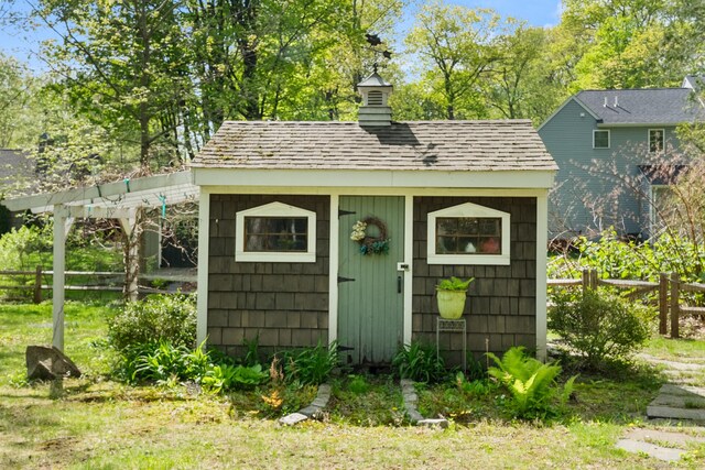 view of outdoor structure with an outbuilding and fence
