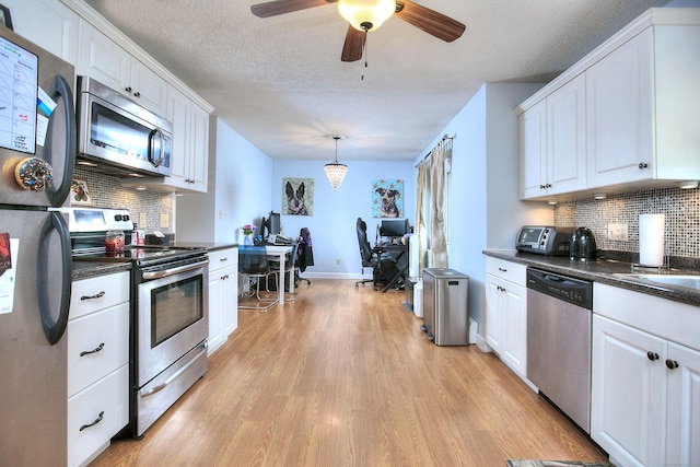 116 Hill St Unit 23, Milford, CT 06460 - kitchen with light wood finished floors, white cabinets, dark countertops, and stainless steel appliances