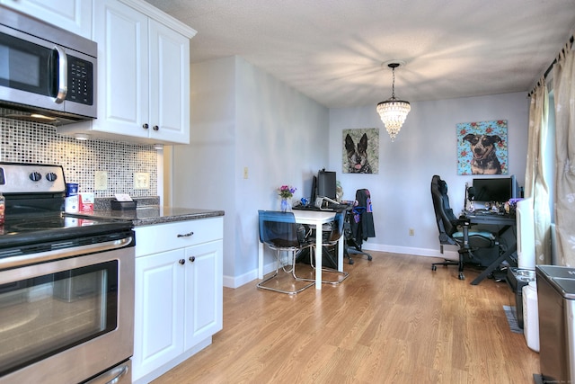116 Hill St Unit 23, Milford, CT 06460 - kitchen with appliances with stainless steel finishes, light wood finished floors, white cabinetry, baseboards, and backsplash
