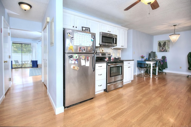 116 Hill St Unit 23, Milford, CT 06460 - kitchen with white cabinets, dark countertops, appliances with stainless steel finishes, and light wood-style flooring