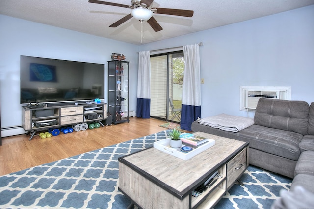 116 Hill St Unit 23, Milford, CT 06460 - living room with ceiling fan, a wall mounted AC, baseboard heating, wood finished floors, and a baseboard heating unit