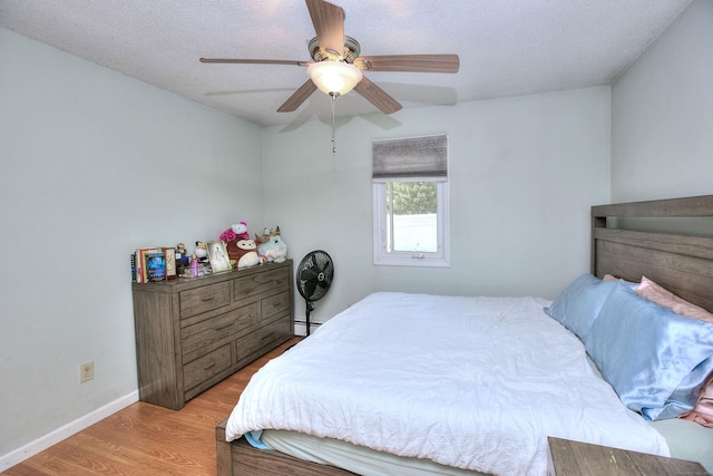 116 Hill St Unit 23, Milford, CT 06460 - bedroom with a textured ceiling, baseboards, ceiling fan, and wood finished floors