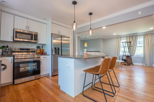 825 Maple Hill Rd, Naugatuck, CT 06770 - kitchen with stainless steel appliances, crown molding, light wood finished floors, a kitchen breakfast bar, and backsplash