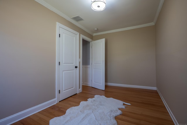 unfurnished bedroom featuring light wood finished floors, ornamental molding, and baseboards