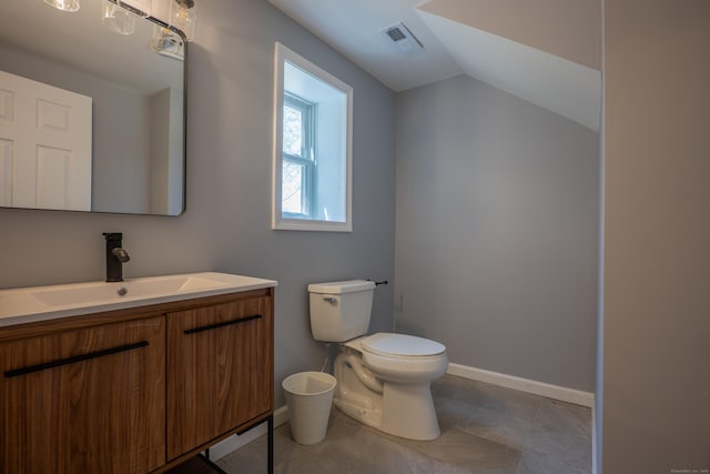 bathroom featuring toilet, vanity, lofted ceiling, baseboards, and tile patterned floors