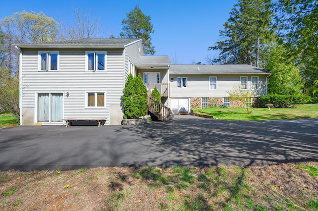 view of front of house with stairway and aphalt driveway