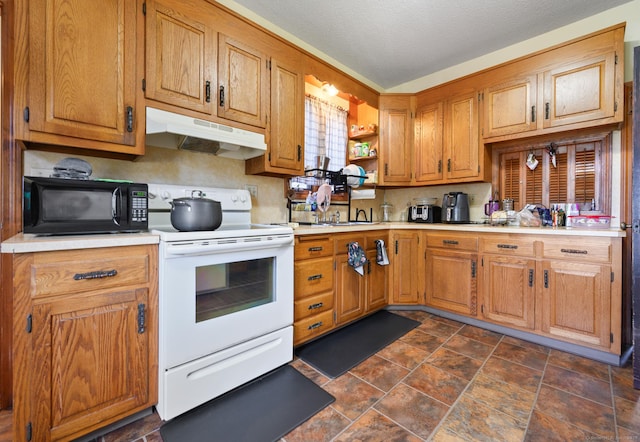 kitchen with black microwave, white range with electric cooktop, light countertops, under cabinet range hood, and stone finish flooring