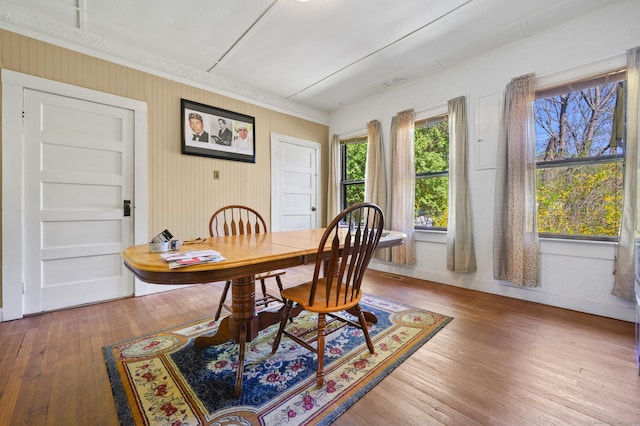 dining area with crown molding, baseboards, and wood-type flooring