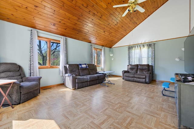 living area featuring baseboards, ceiling fan, and a wealth of natural light