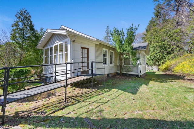 rear view of property featuring a lawn and a sunroom