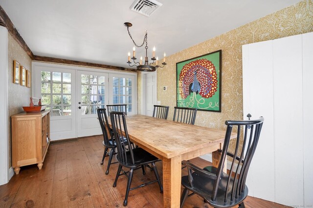 149 Limekiln Rd, Redding, CT 06896 - dining area with wallpapered walls, french doors, a chandelier, and hardwood / wood-style floors