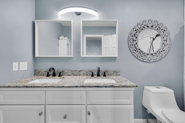 bathroom featuring double vanity and toilet