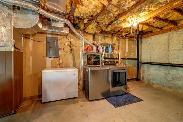 unfinished below grade area with white refrigerator, washing machine and clothes dryer, and electric panel