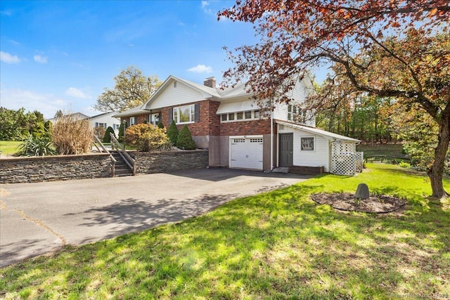 ranch-style home with brick siding, a garage, a front yard, a chimney, and driveway