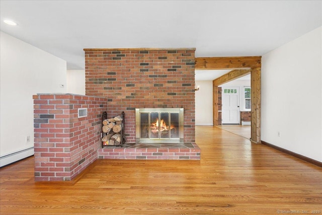 unfurnished living room featuring a fireplace, recessed lighting, baseboards, wood finished floors, and a baseboard radiator