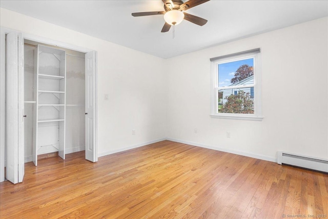 unfurnished bedroom featuring light wood-style floors, a baseboard radiator, baseboards, and a ceiling fan