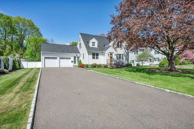 new england style home with an attached garage, driveway, and roof with shingles