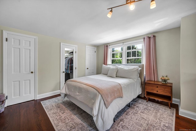 bedroom with baseboards, dark wood finished floors, and a closet