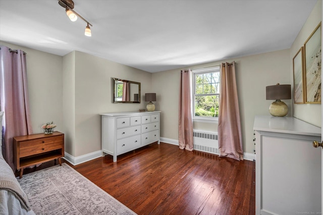 bedroom with radiator, dark wood-style floors, and baseboards