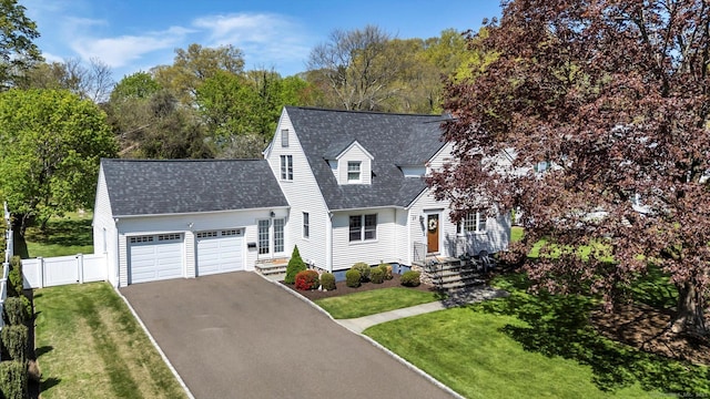 cape cod house featuring driveway, a garage, and a shingled roof