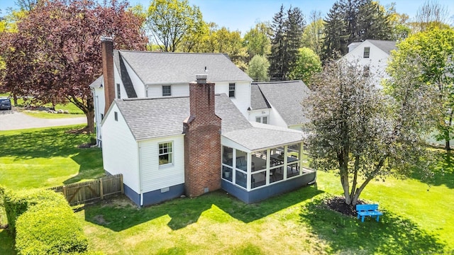 rear view of house with a chimney, a sunroom, a shingled roof, and crawl space