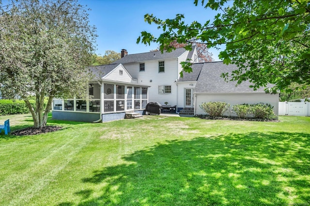 back of house featuring a sunroom, a chimney, and a shingled roof