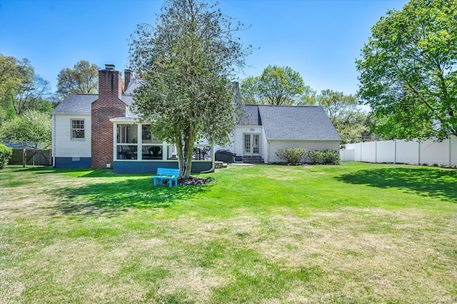 back of house featuring french doors, a sunroom, a chimney, and a shingled roof