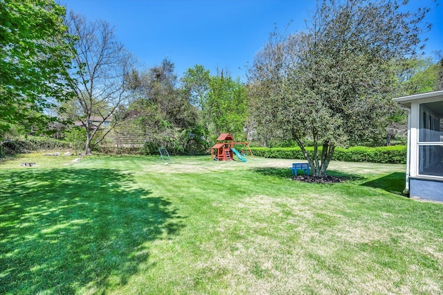 view of green lawn featuring a playground