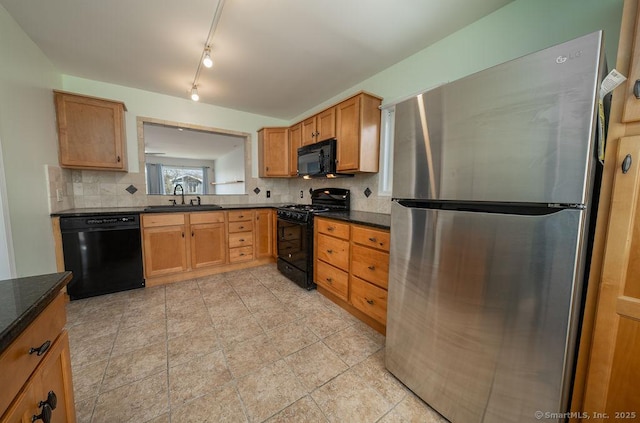 kitchen with backsplash, dark countertops, a sink, and black appliances