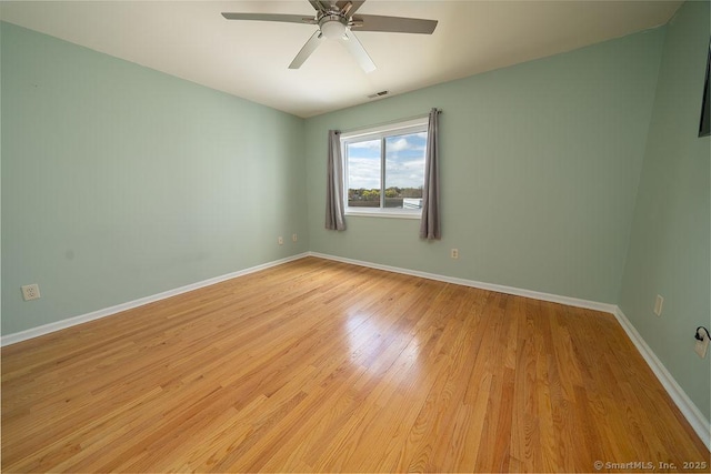 spare room featuring baseboards, a ceiling fan, light wood finished floors, and visible vents