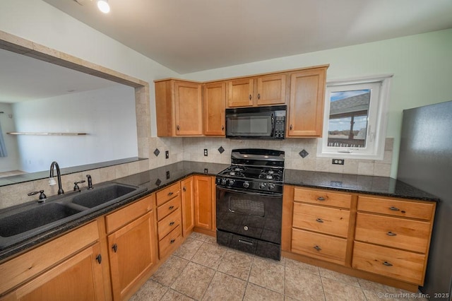 kitchen with tasteful backsplash, a sink, light tile patterned floors, black appliances, and dark stone counters