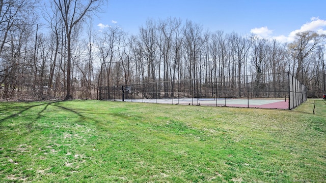 view of yard with a tennis court and fence