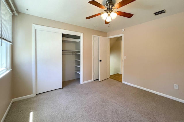 unfurnished bedroom with light colored carpet, a ceiling fan, baseboards, and visible vents