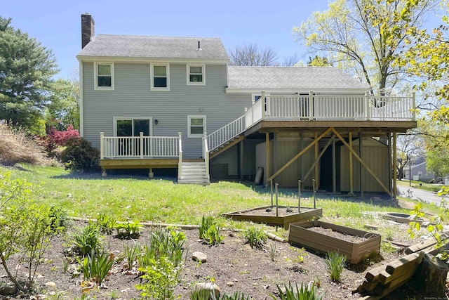 rear view of property featuring stairway, a chimney, a garden, and a wooden deck