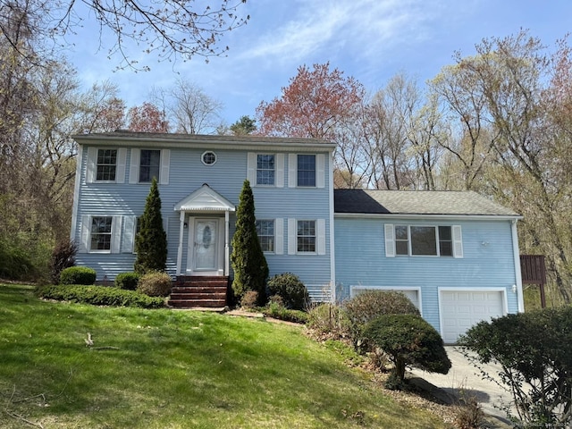 colonial inspired home featuring a front lawn and a garage