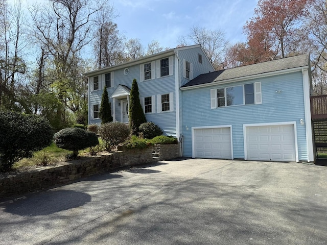 colonial home with an attached garage and driveway