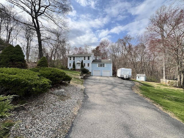 view of front of house with a garage, a front lawn, and aphalt driveway
