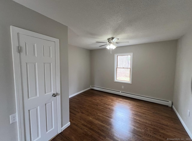 empty room with baseboards, baseboard heating, dark wood-style floors, a textured ceiling, and a ceiling fan