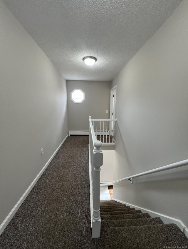 stairs featuring baseboards, a textured ceiling, carpet, and baseboard heating
