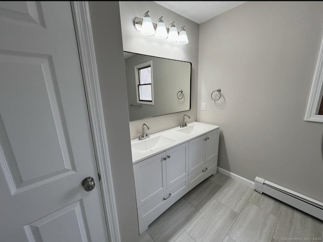 full bath with double vanity, baseboard heating, baseboards, and a sink